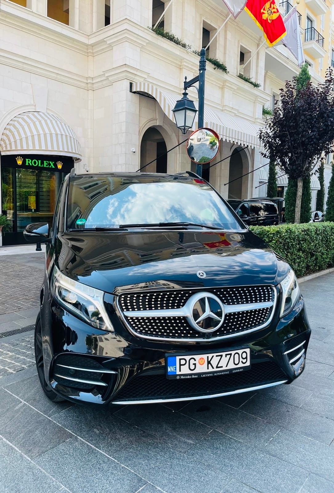 Crni Mercedes-Benz kombi parkiran ispred Rolex prodavnice u luksuznom šoping distriktu