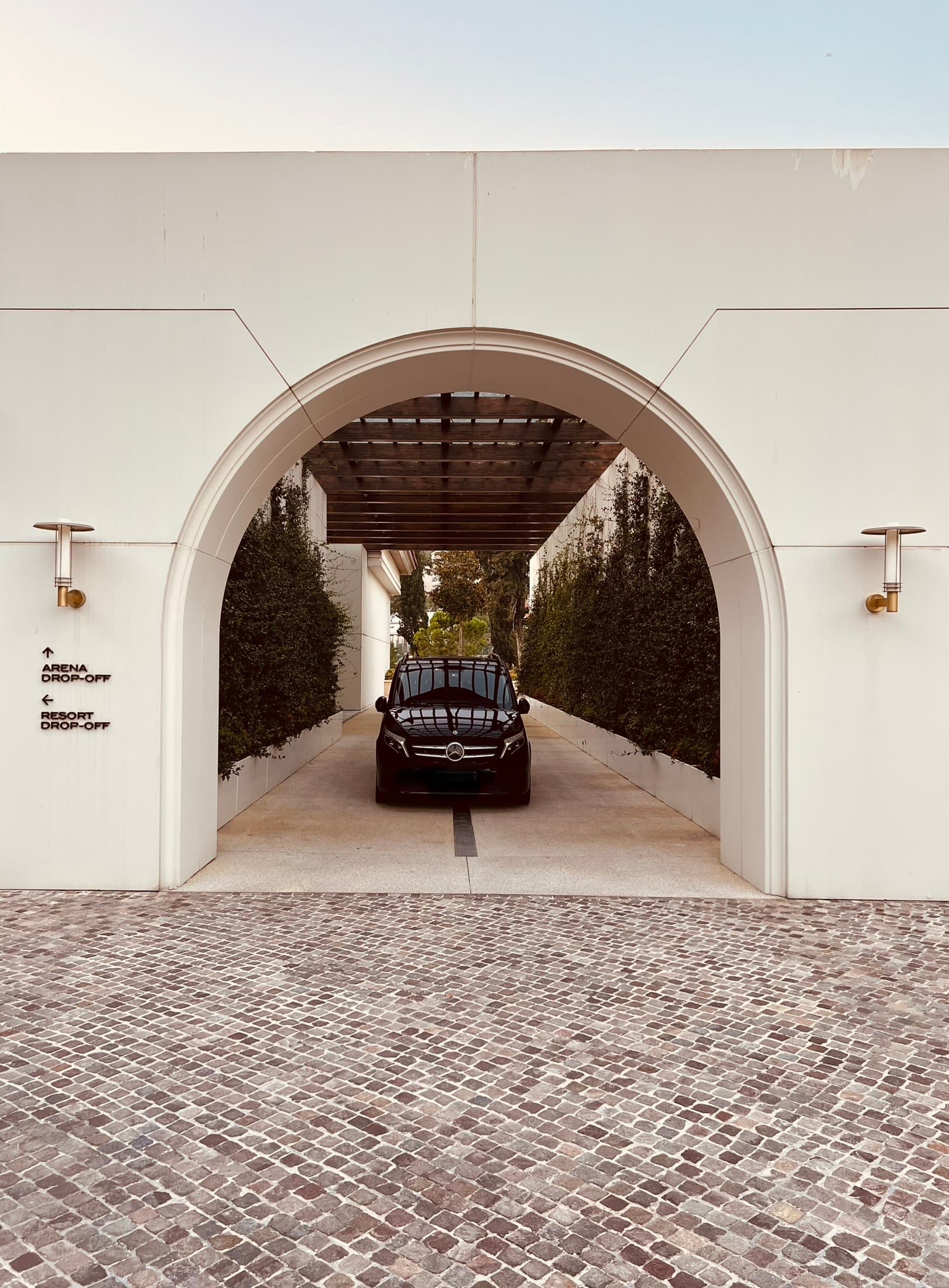 Crni Mercedes-Benz kombi parkiran ispod luka na ulazu u resort