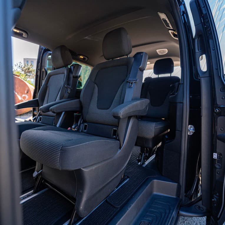 Pogled na unutrašnjost Mercedes-Benz kombija sa sjedištima okrenutim naprijed i otvorenim kliznim vratima