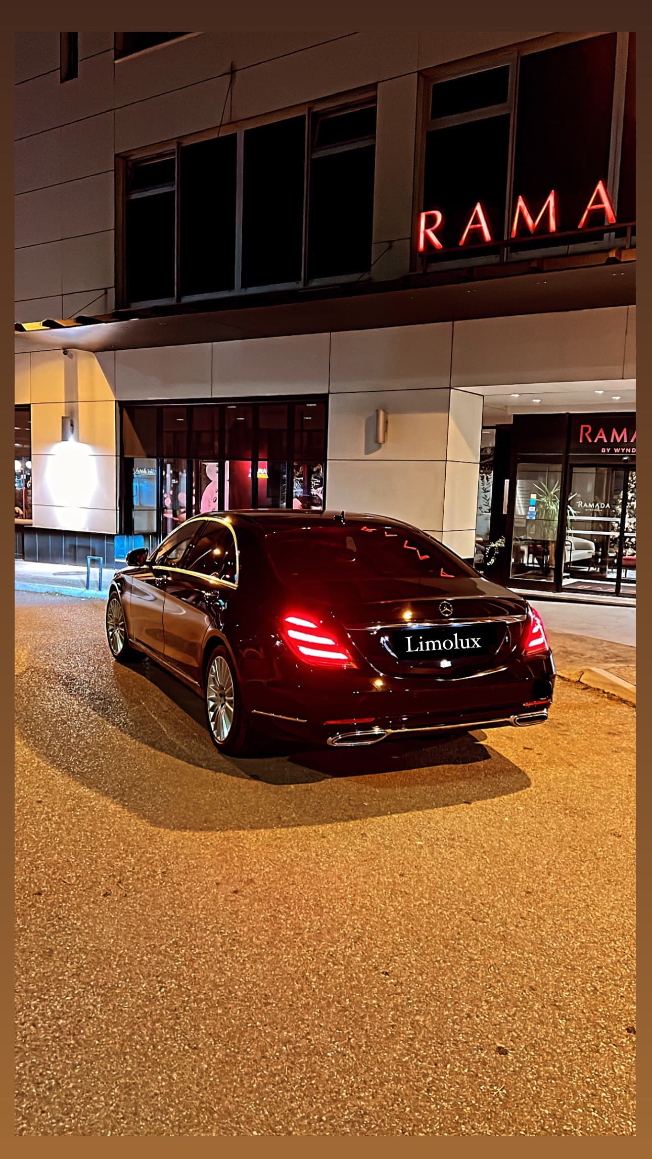 Pogled s leđa na crni Mercedes-Benz sedan noću ispred hotela