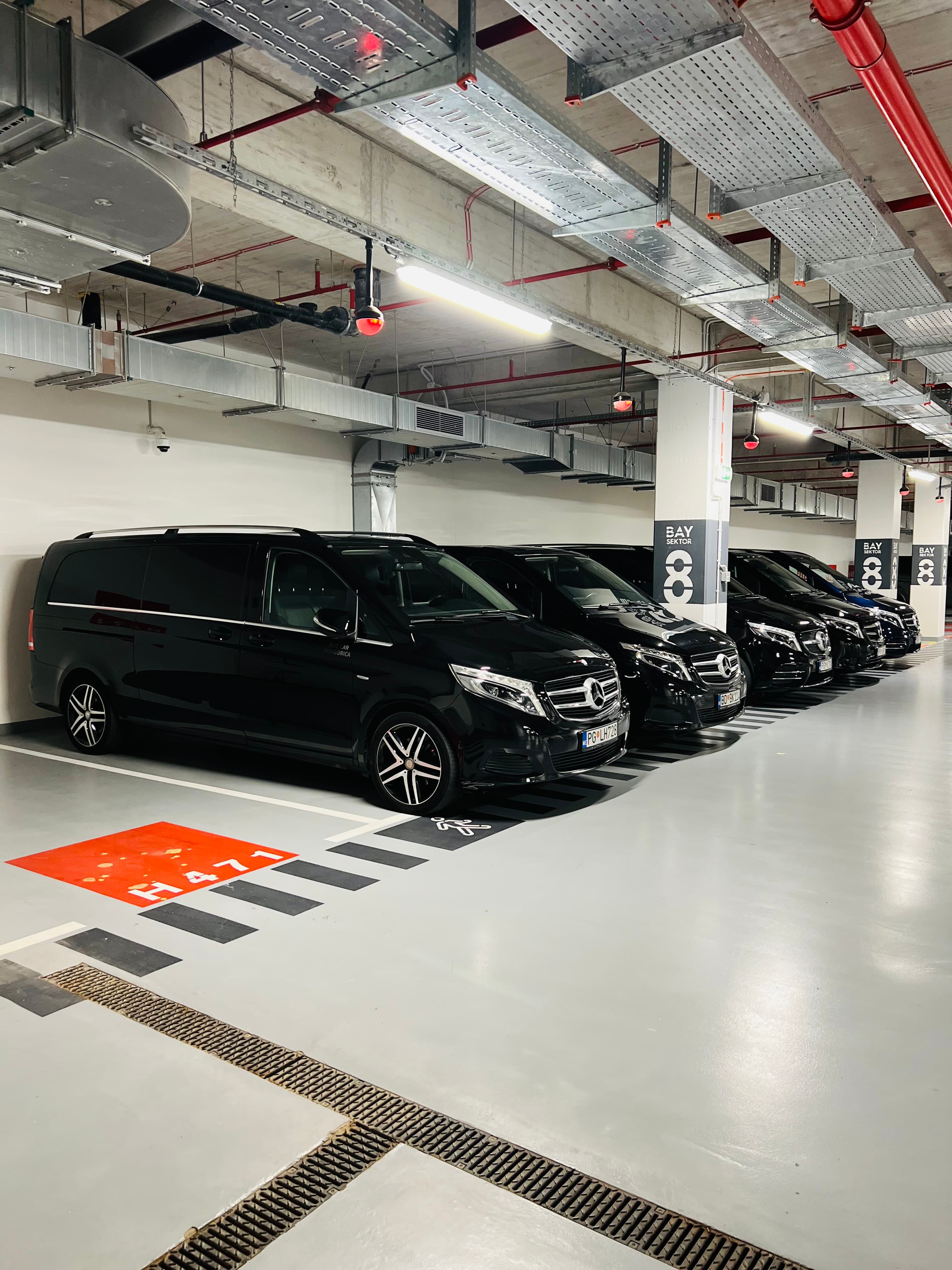 Red crnih Mercedes-Benz kombija parkiranih u zatvorenoj garaži